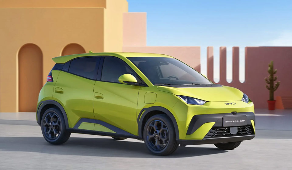 BYD Dolphin Surf eléctrico azul cargándose en una ciudad costera mediterránea